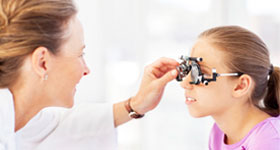 Optician examining girl's eyes