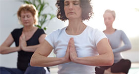 Mature women in yoga class