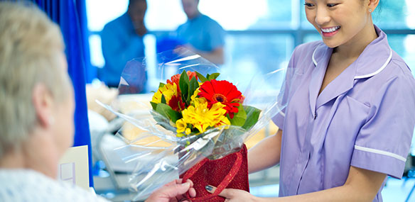 volunteer delivering flowers to elderly patient