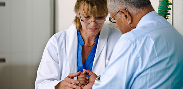 Doctor checking hand movement of male patient