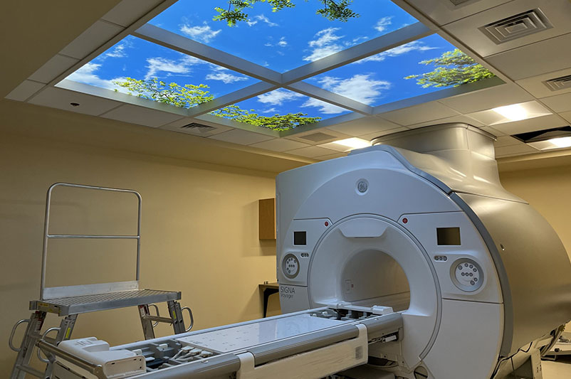MRI machine in hospital room with medical equipment.