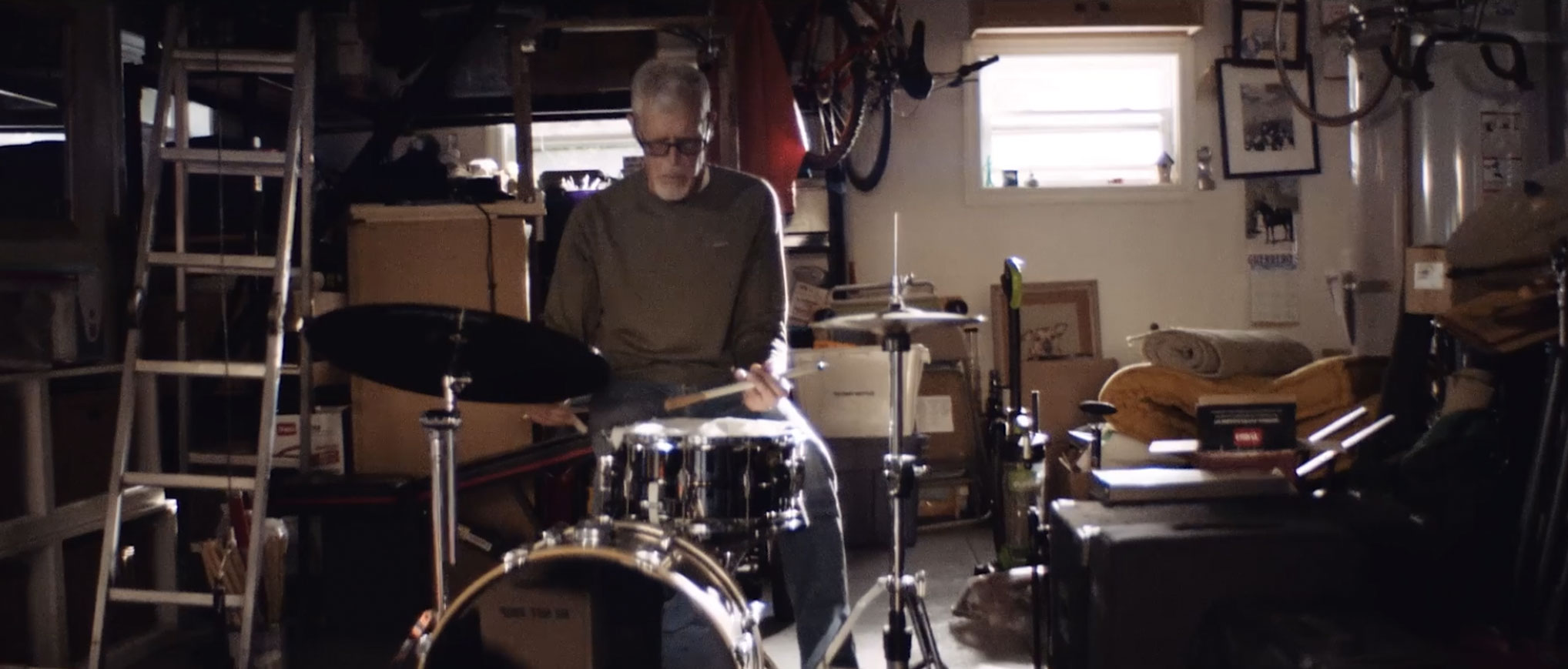 A man in his basement playing the drums.