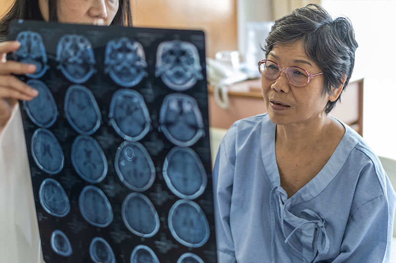 A woman and a doctor examining an MRI scan together.