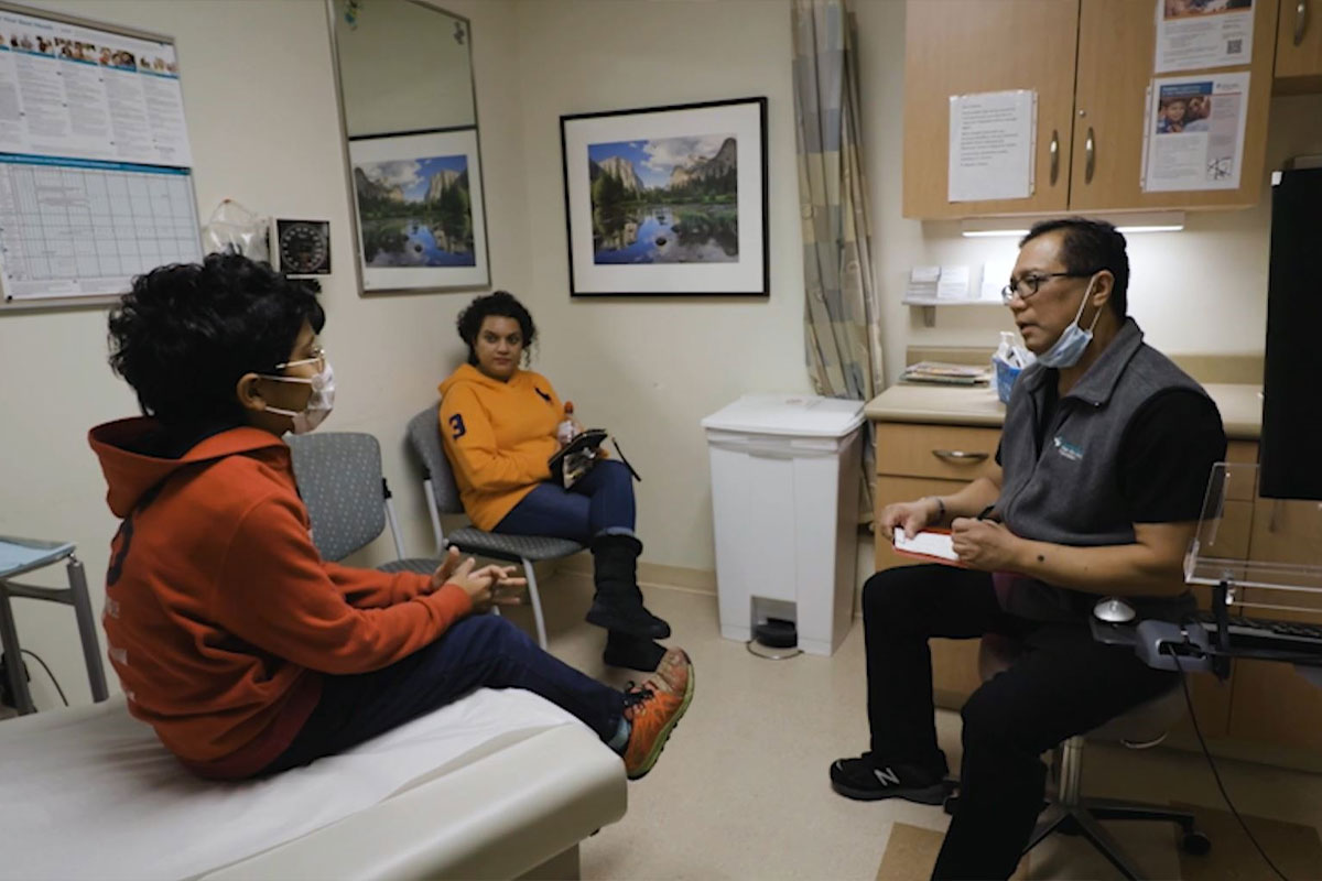 A doctor discussing with a patient in a hospital room.